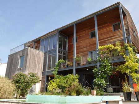 Située en pleine ville en Charente-Maritime, cette propriété avec une construction à ossature bois bioclimatique et un bassin de baignade naturelle rime avec écologie, économie, confort et … éventuellement travail à domicile.