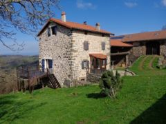 Bâtiments ferme écologique - Une terrasse en bois orientée Sud et Ouest - parasol à prévoir… -  fait le tour de la maison avec une vue sur les monts de la Margeride.